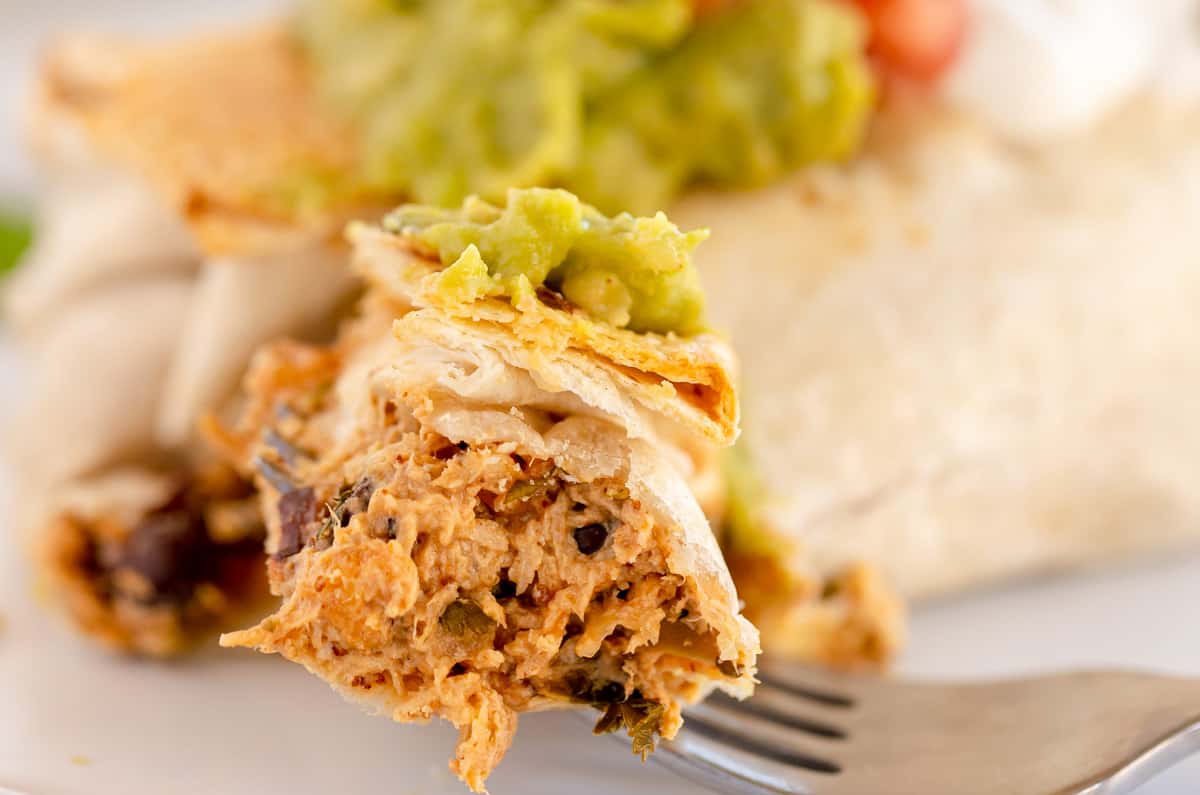 chicken chimichanga on a fork, cut open to show inside.
