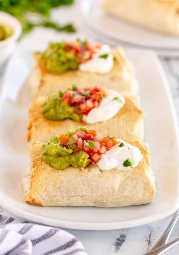 baked chicken chimichangas on a white plate.