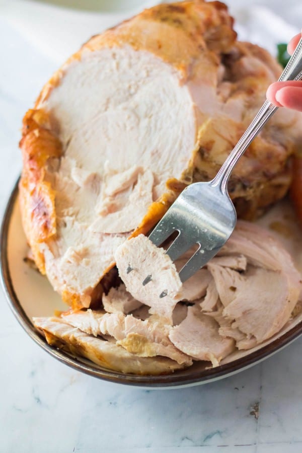 Slow Cooker Turkey Breast that is sliced, and on a fork.