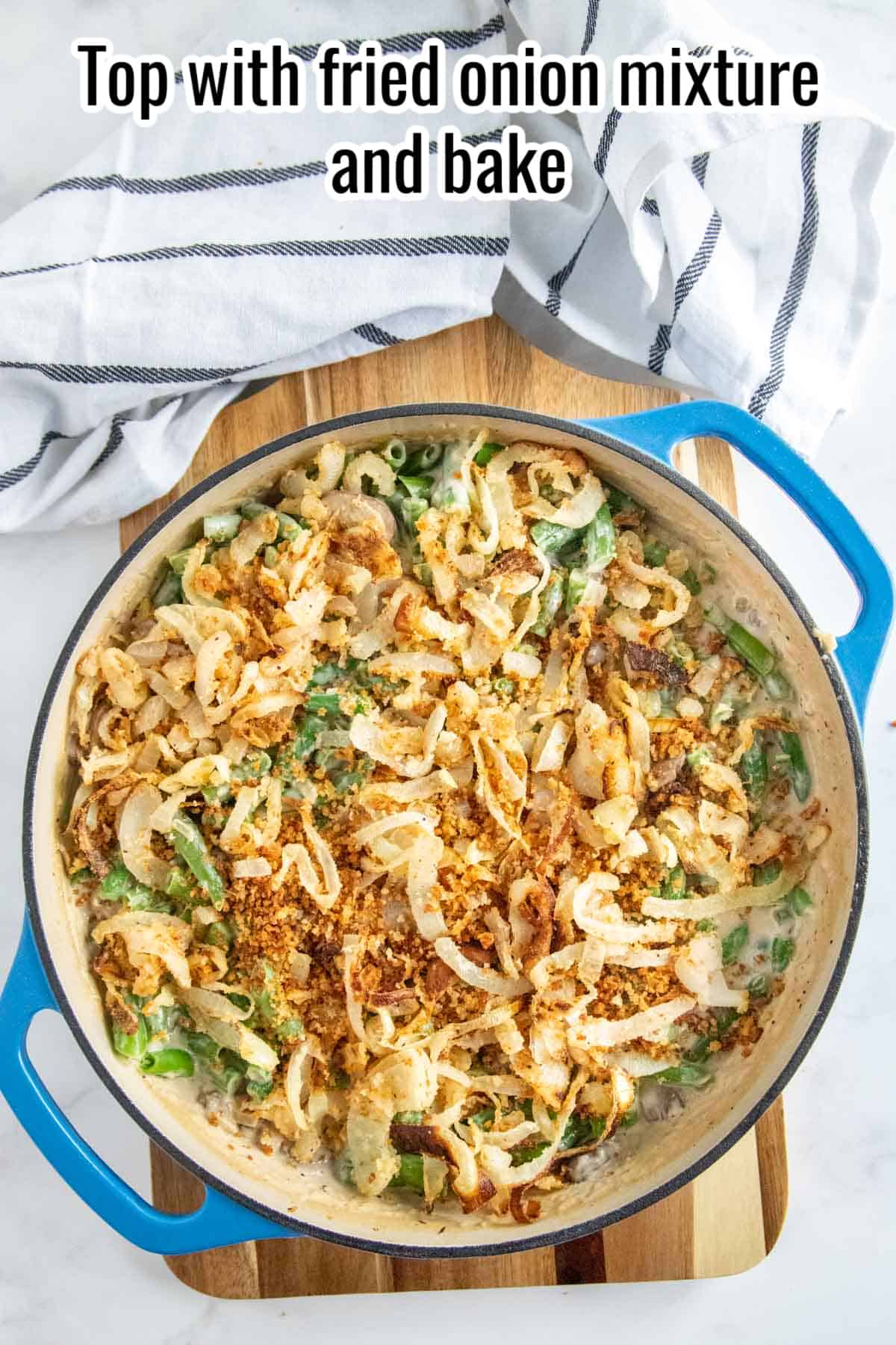 green bean casserole in a blue skillet with topping.