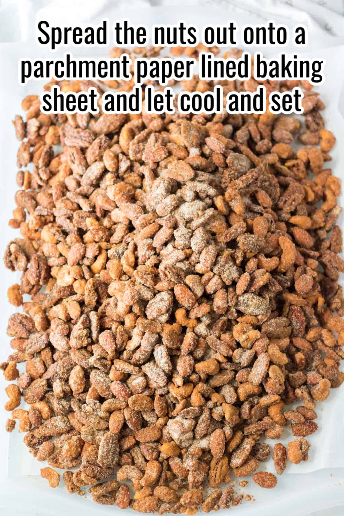 cooled candied nuts on a baking sheet with instructions overlaid in text.
