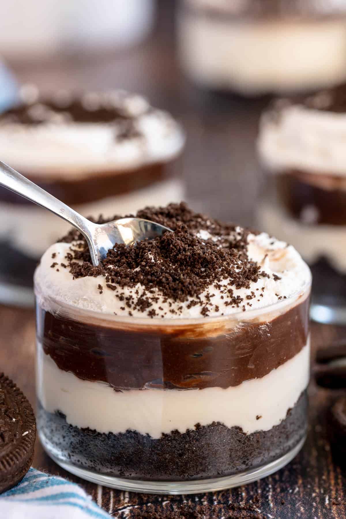 oreo dirt pudding in a glass with a spoon.