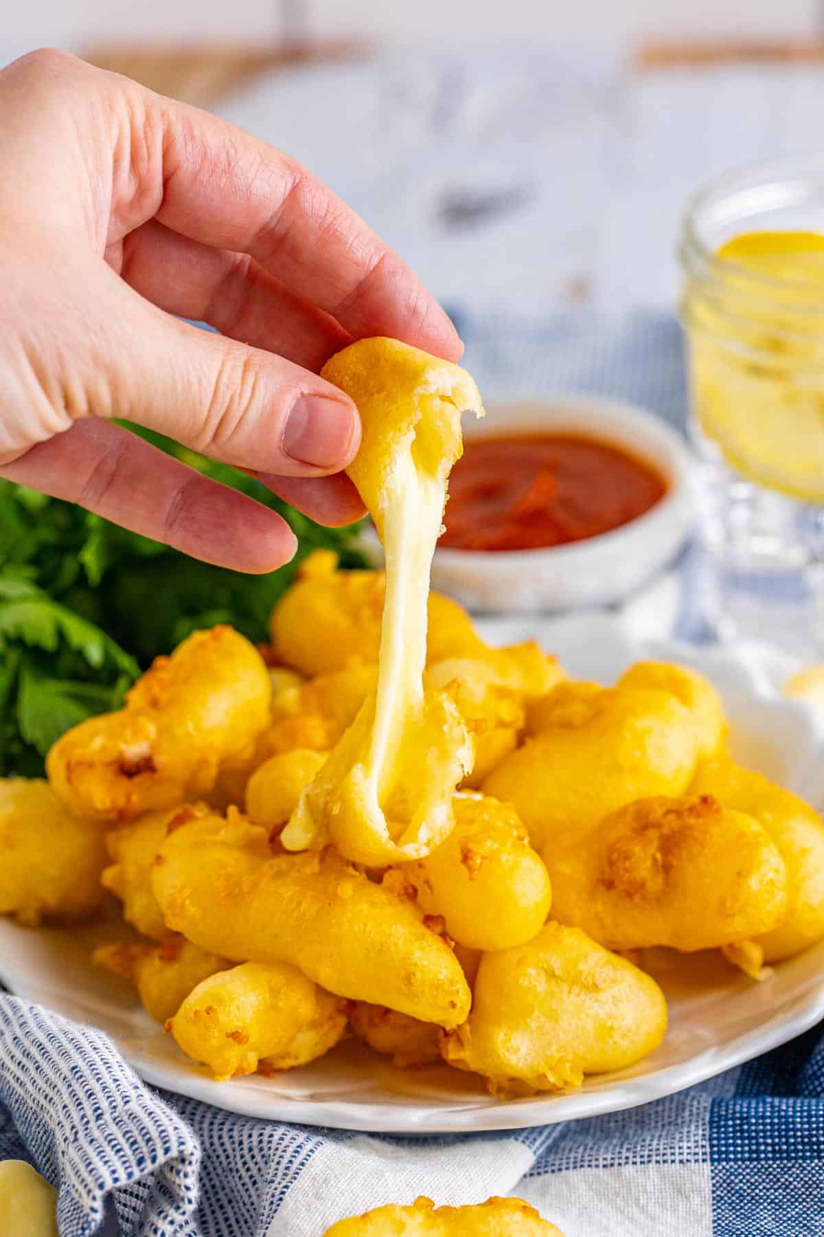 cheese curds being pulled with cheese.
