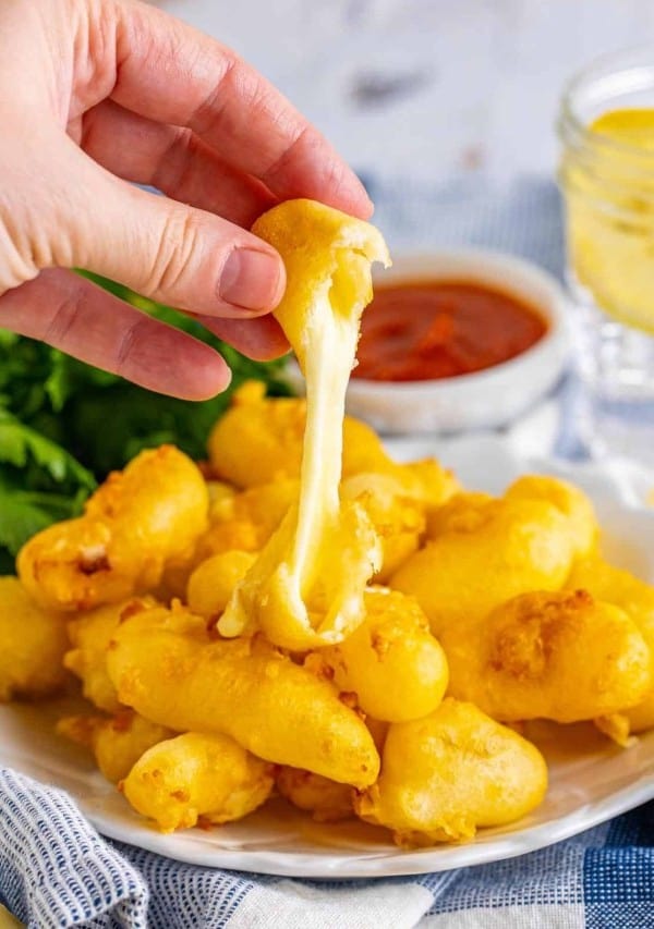 cheese curds being pulled with cheese.