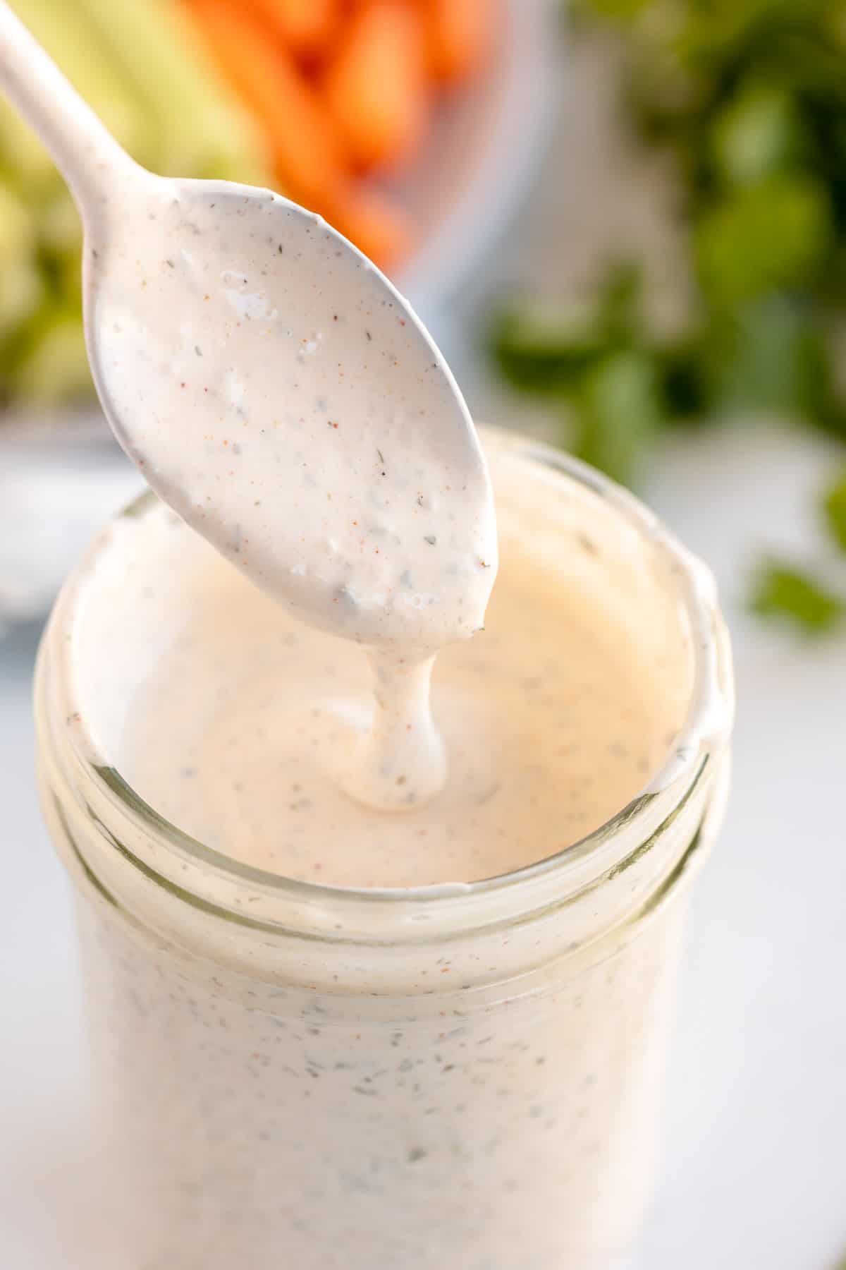 spoon of ranch dressing in a jar.
