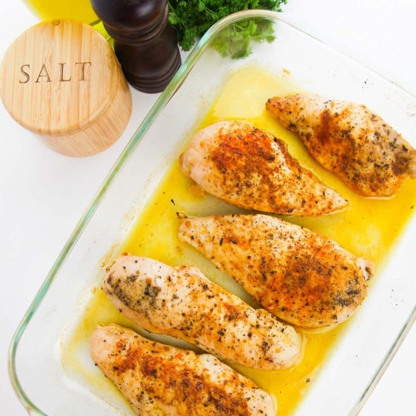 baked chicken breasts in a clear baking dish.