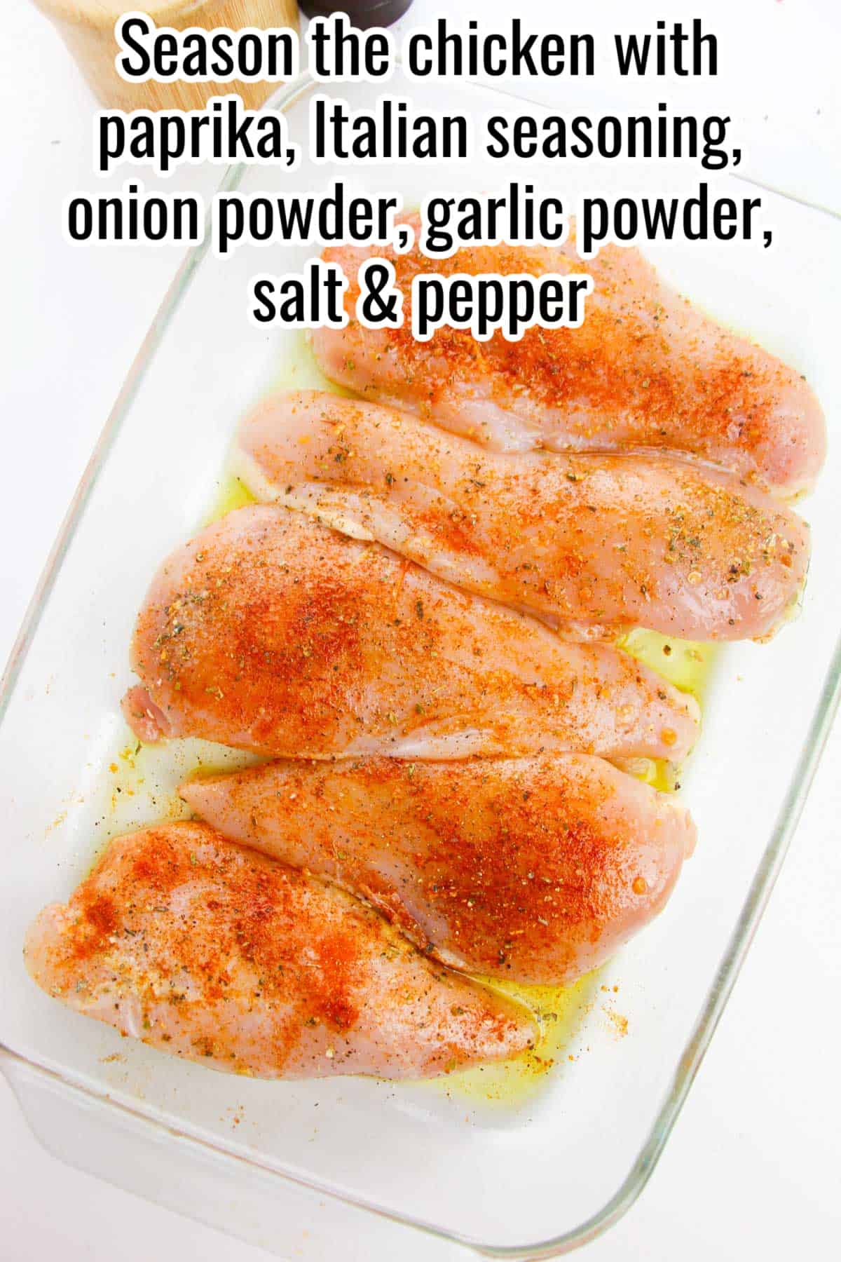 raw seasoned chicken breasts in a baking dish with instructions overlaid in text.