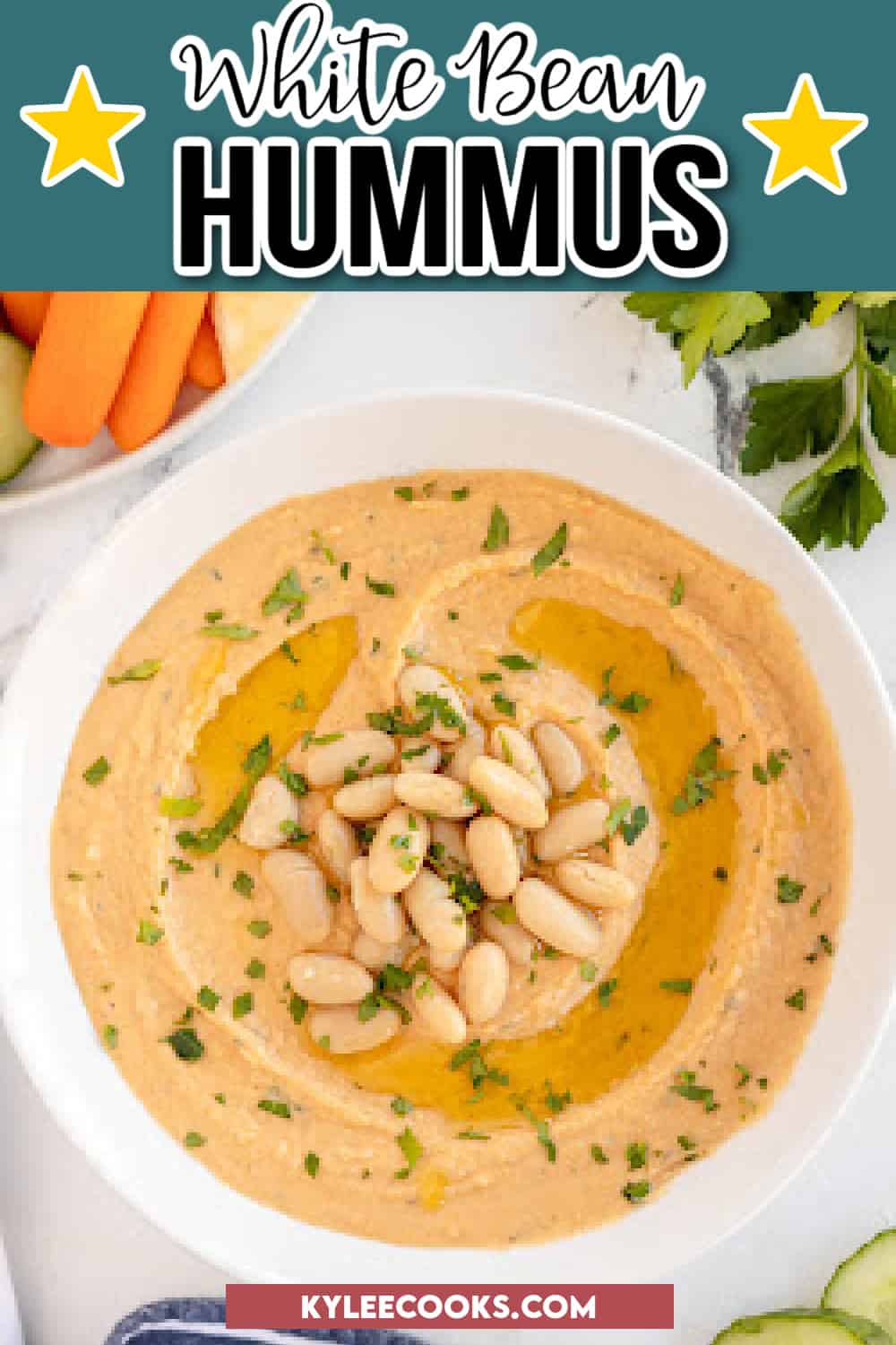 white bean hummus with white beans and parsley in a white bowl.