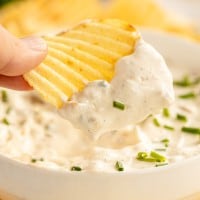 french onion dip in a bowl with a chip grabbing dip.