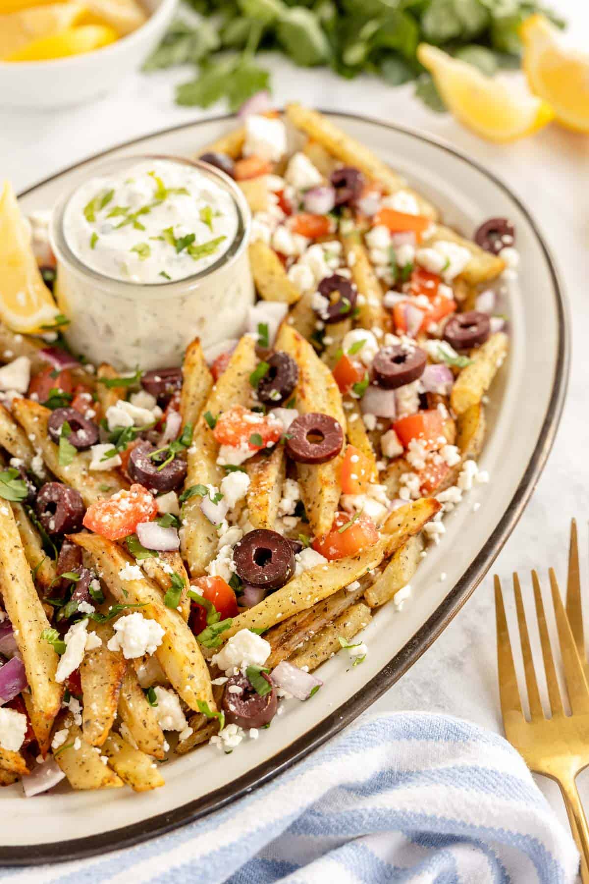 white oval platter with greek fries on it.