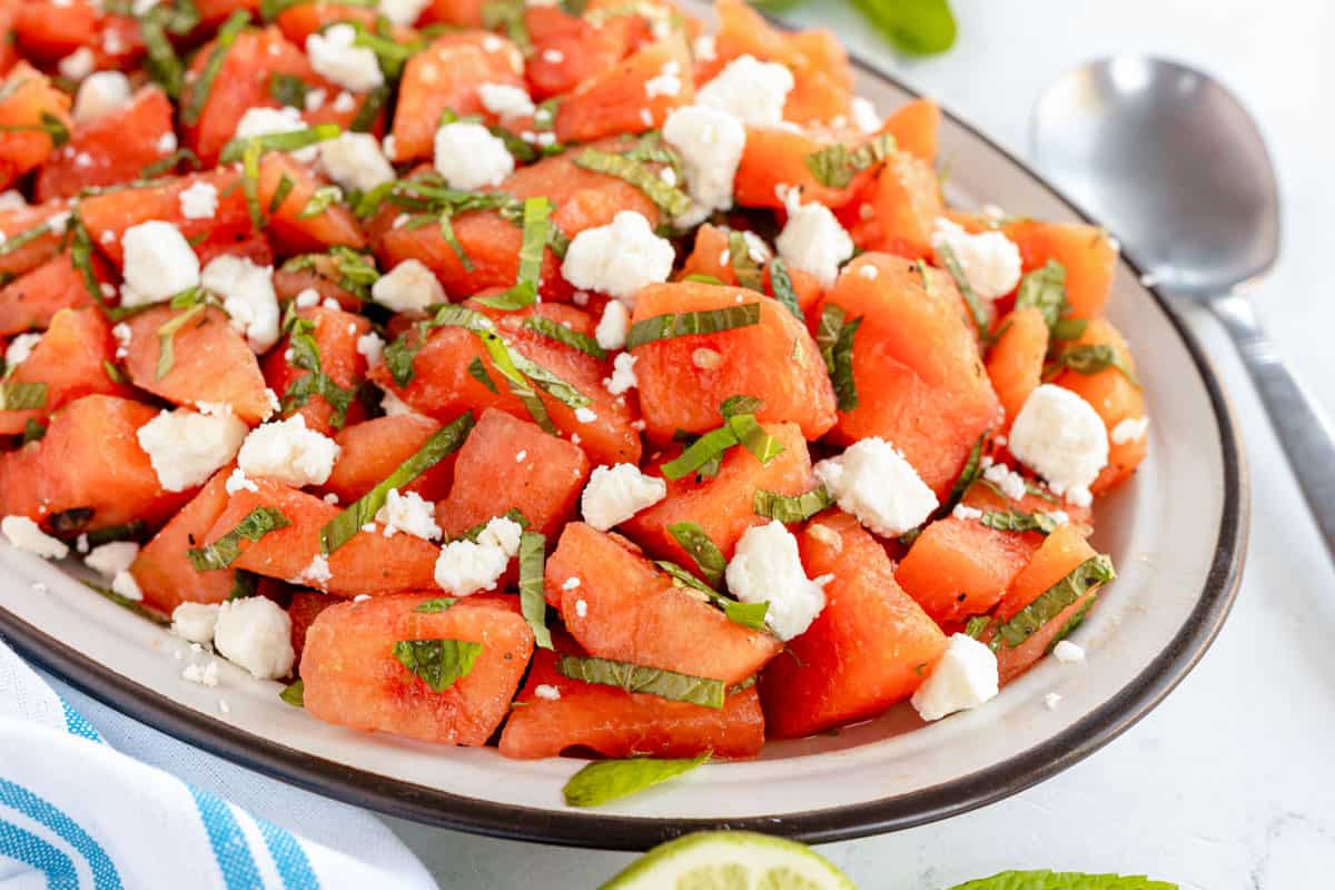 watermelon salad on an oval plate with a spoon.