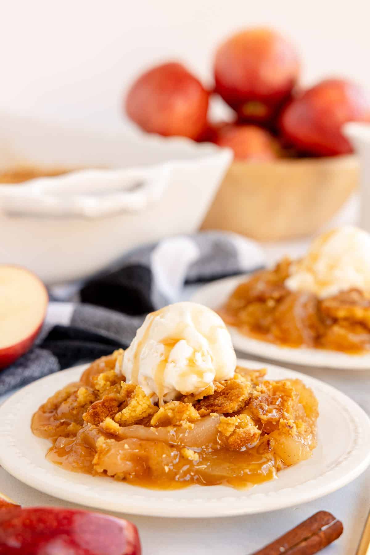 A plate of Apple Dump Cake with ice cream and apples.