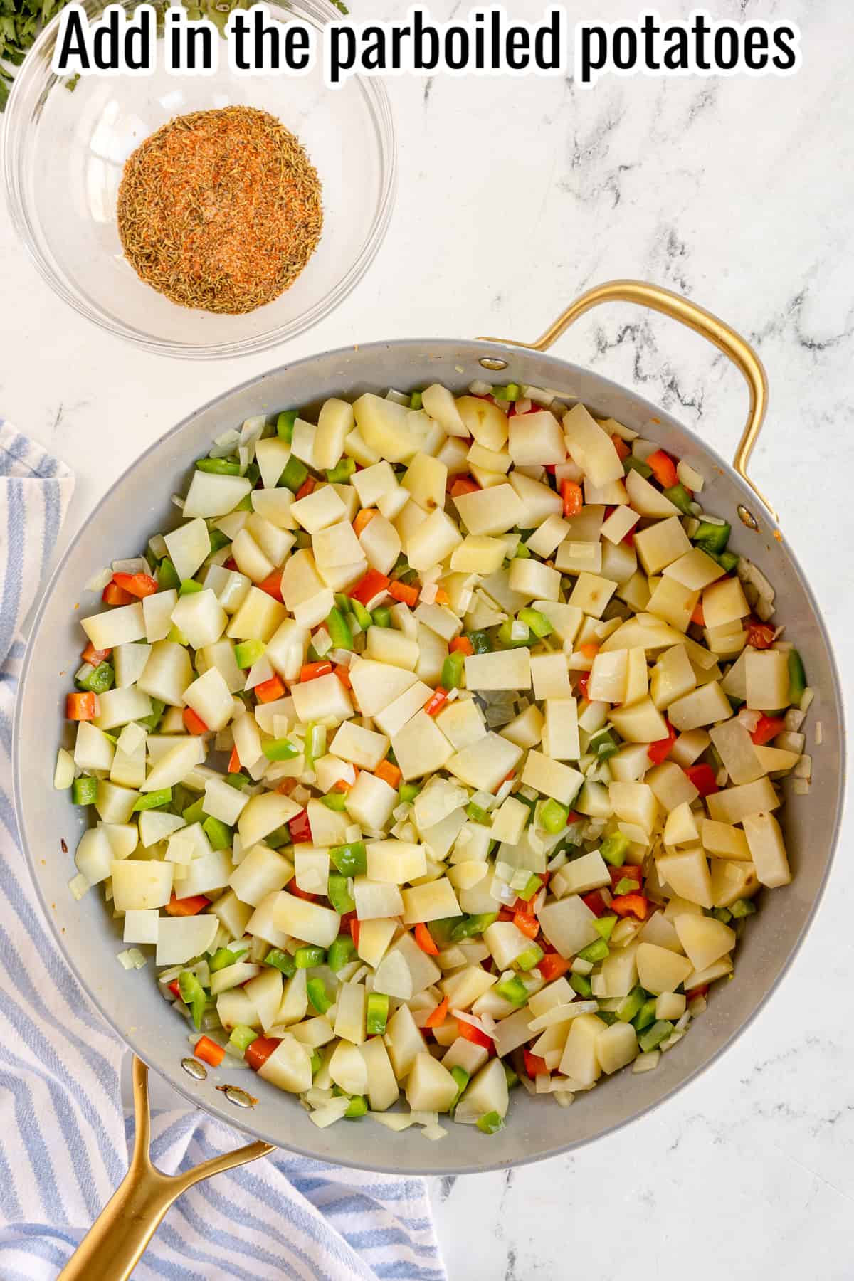 raw potatoes, diced peppers and onions in a skillet.