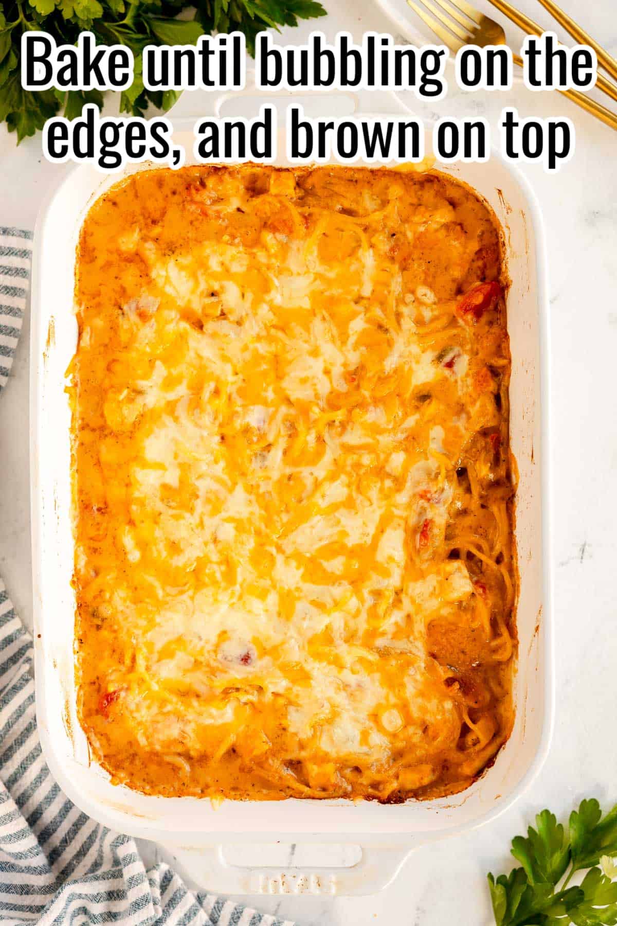 A creamy chicken casserole dish with the words bake until bubbling on the edges, and brown on top.