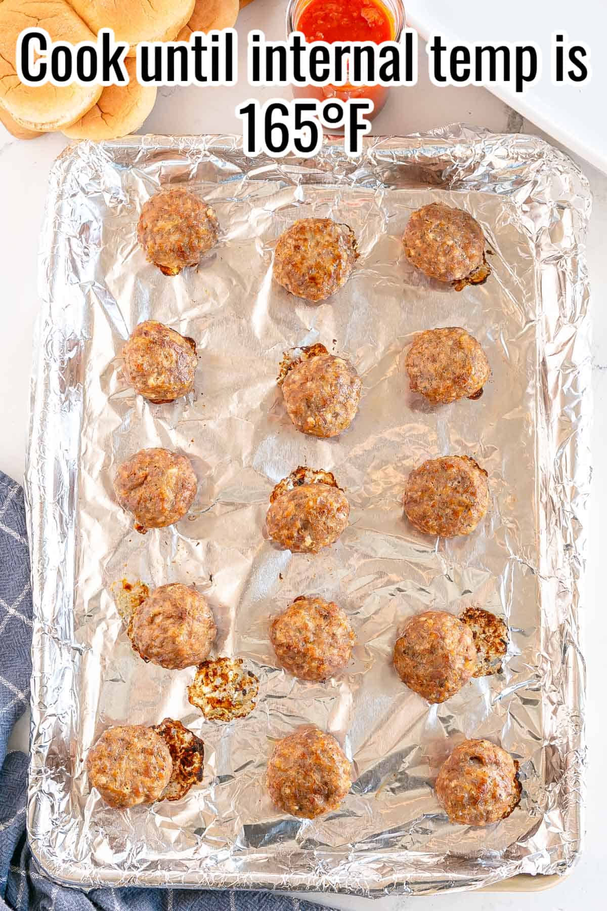 a baking sheet with cooked meatballs.