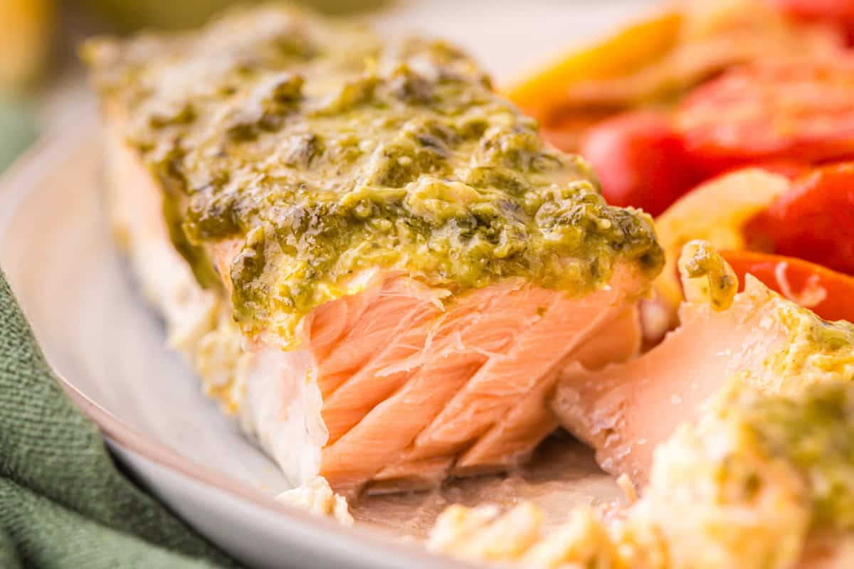 salmon with pesto sauce on a plate.