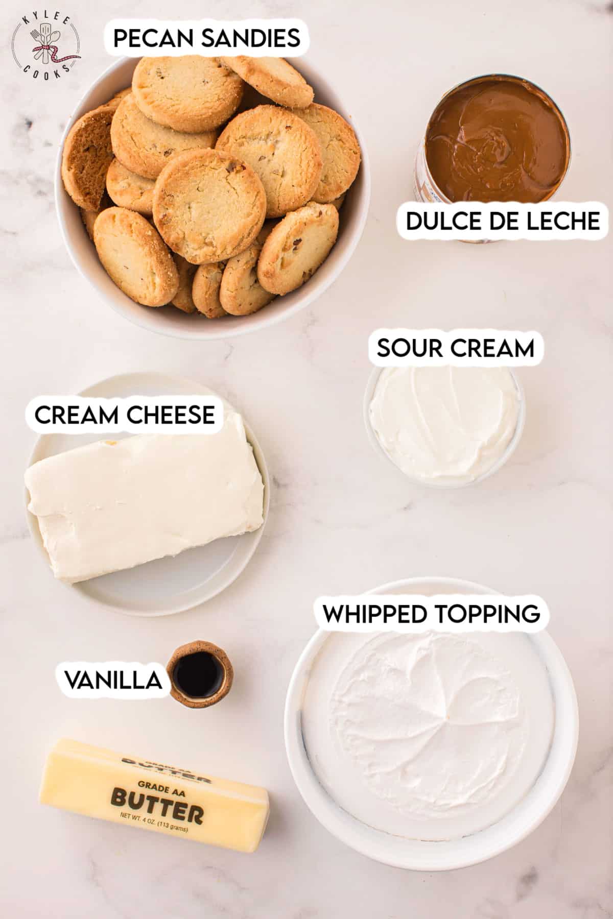 ingredients to make dulce de leche cheesecake laid out and labeled.