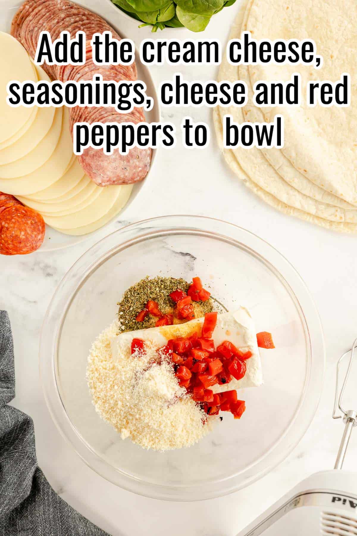 A bowl of cream cheese, seasonings, cheese and roasted red peppers in it.