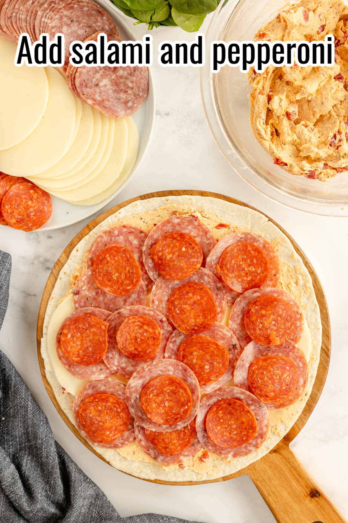 A tortilla with salami and pepperoni laid on top.