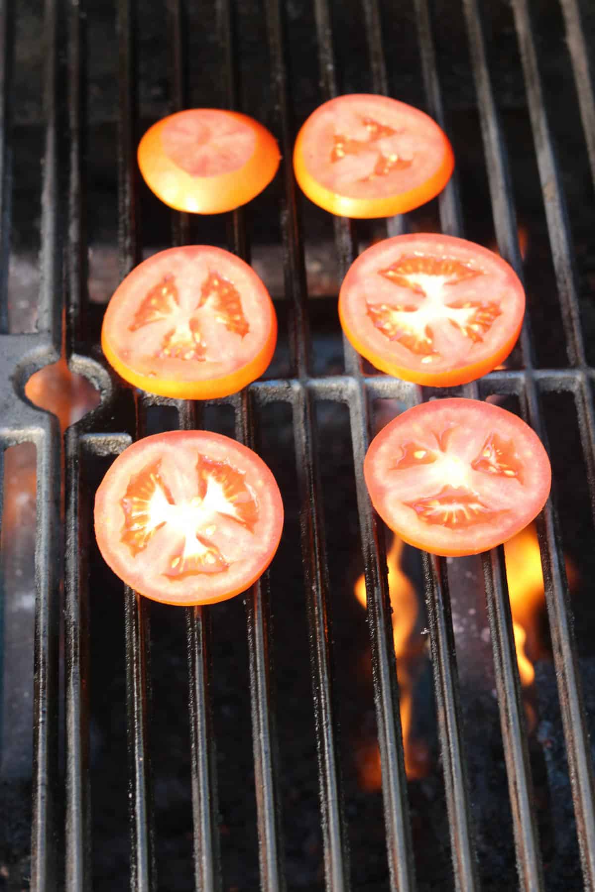 raw tomato slices on a grill.