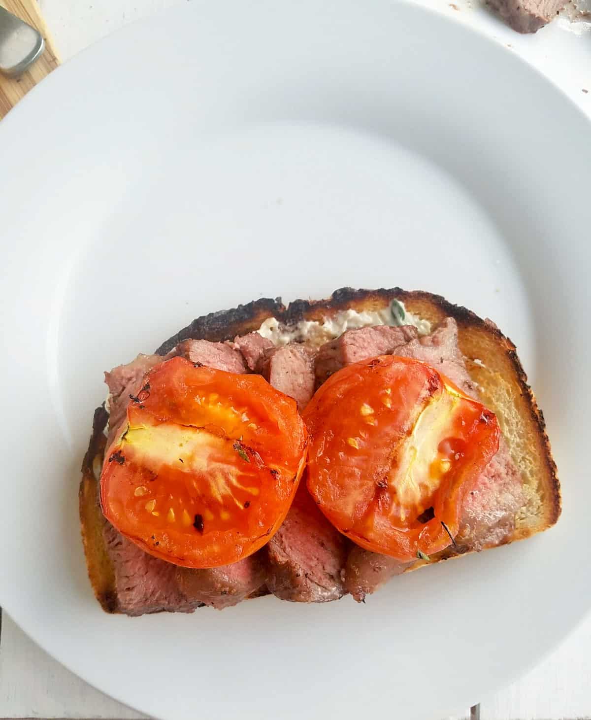 grilled tomatoes on top of steak.