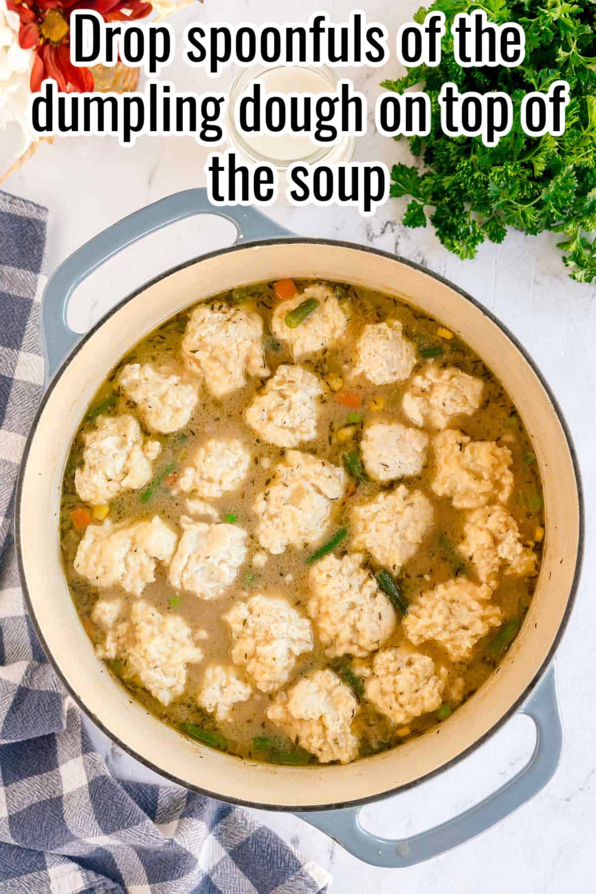 Raw dumpling dough dropped into the pot of soup. Text on the image says 'Drop spoonfuls of the dumpling dough on top of the soup'.