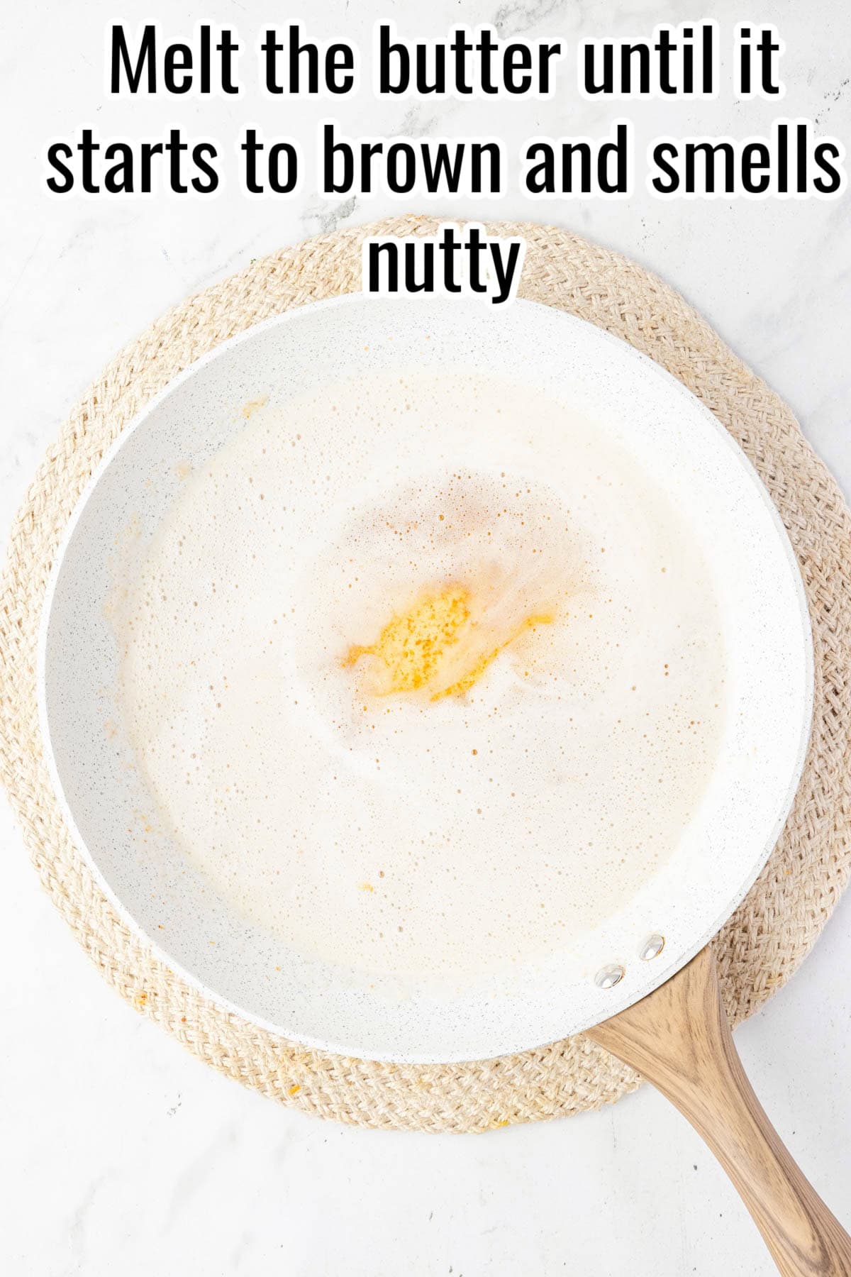 A white skillet with melted butter starting to brown. Text on the image says 'Melt the butter until it starts to brown and smells nutty'.