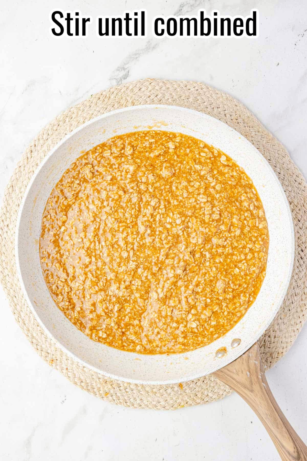 Oatmeal cookie batter fully mixed in a skillet. Text on the image says 'Stir until combined'.