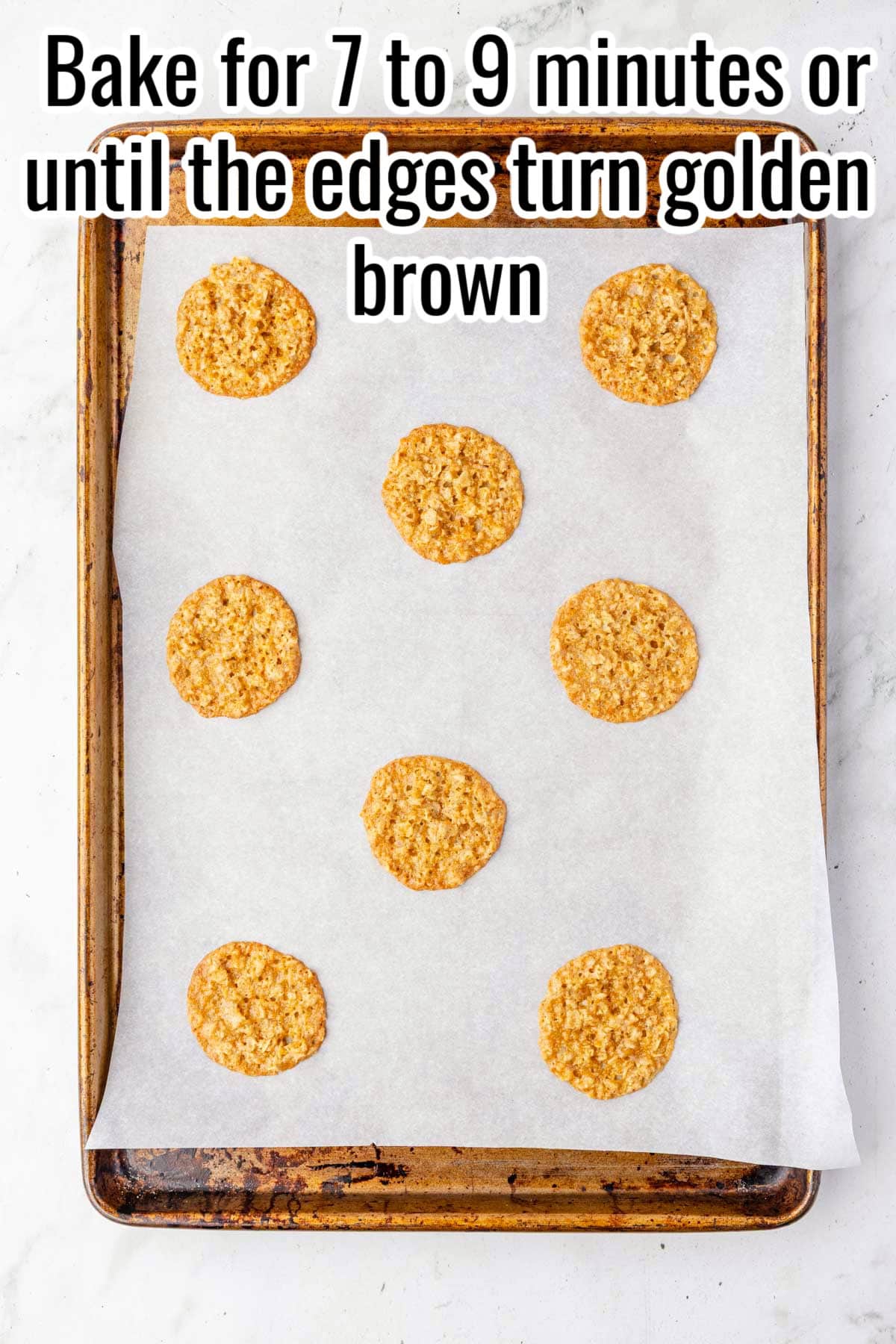 Baked lace cookies spaced on a parchment-lined sheet. Text on the image says 'Bake for 7 to 9 minutes or until the edges turn golden brown'.