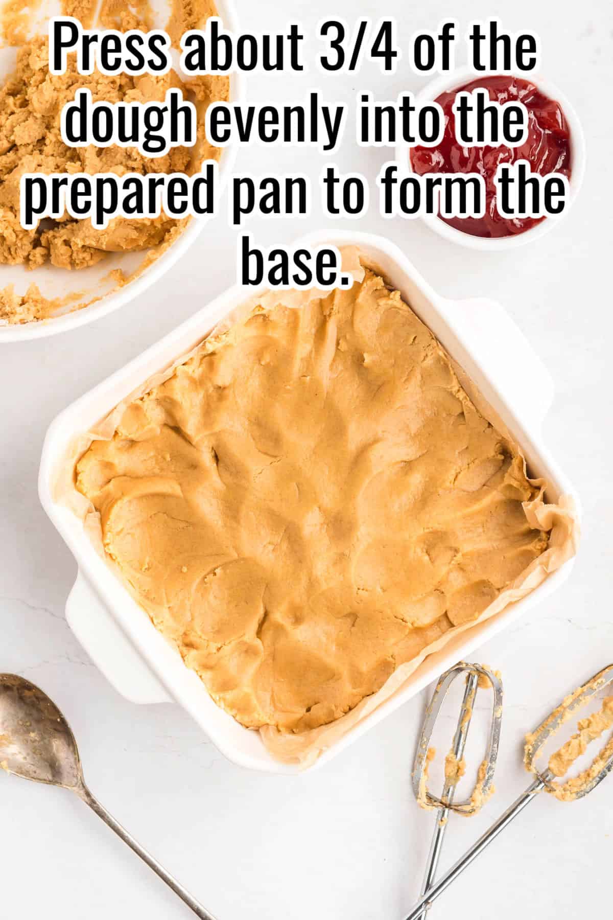 A baking dish with dough pressed evenly into the bottom. Text on the image says 'Press about 3/4 of the dough evenly into the prepared pan to form the base'.