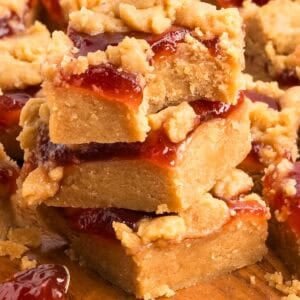 A stack of peanut butter jam bars with jam and crumble layers visible.