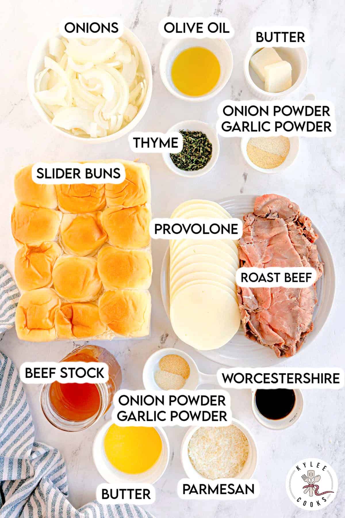 Ingredients arranged on a surface, including roast beef, provolone, slider buns, sliced onions, and seasonings. Text on the image says 'ONIONS', 'OLIVE OIL', 'BUTTER', 'THYME', 'SLIDER BUNS', 'PROVOLONE', 'ROAST BEEF', 'BEEF STOCK', 'ONION POWDER GARLIC POWDER', 'WORCESTERSHIRE', 'PARMESAN'.