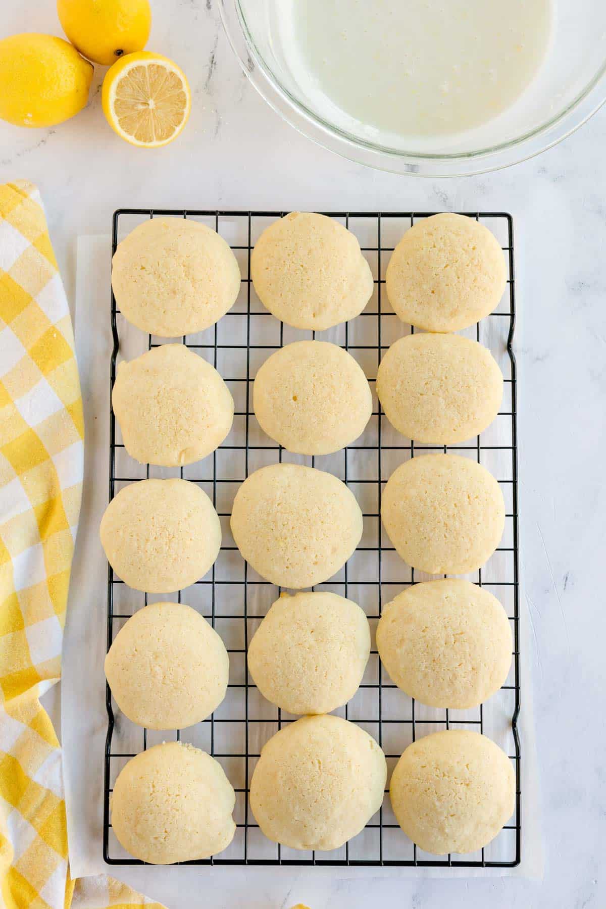 Baked lemon cookies cooling on a wire rack.