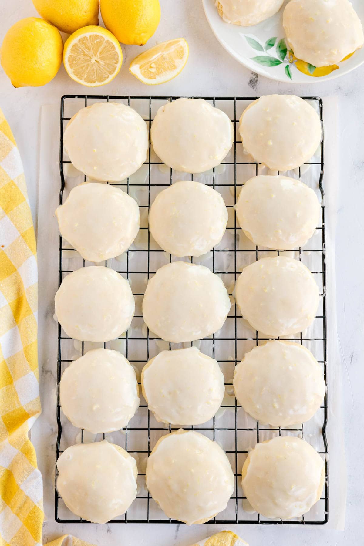 Glazed lemon cookies lined up on a wire rack.