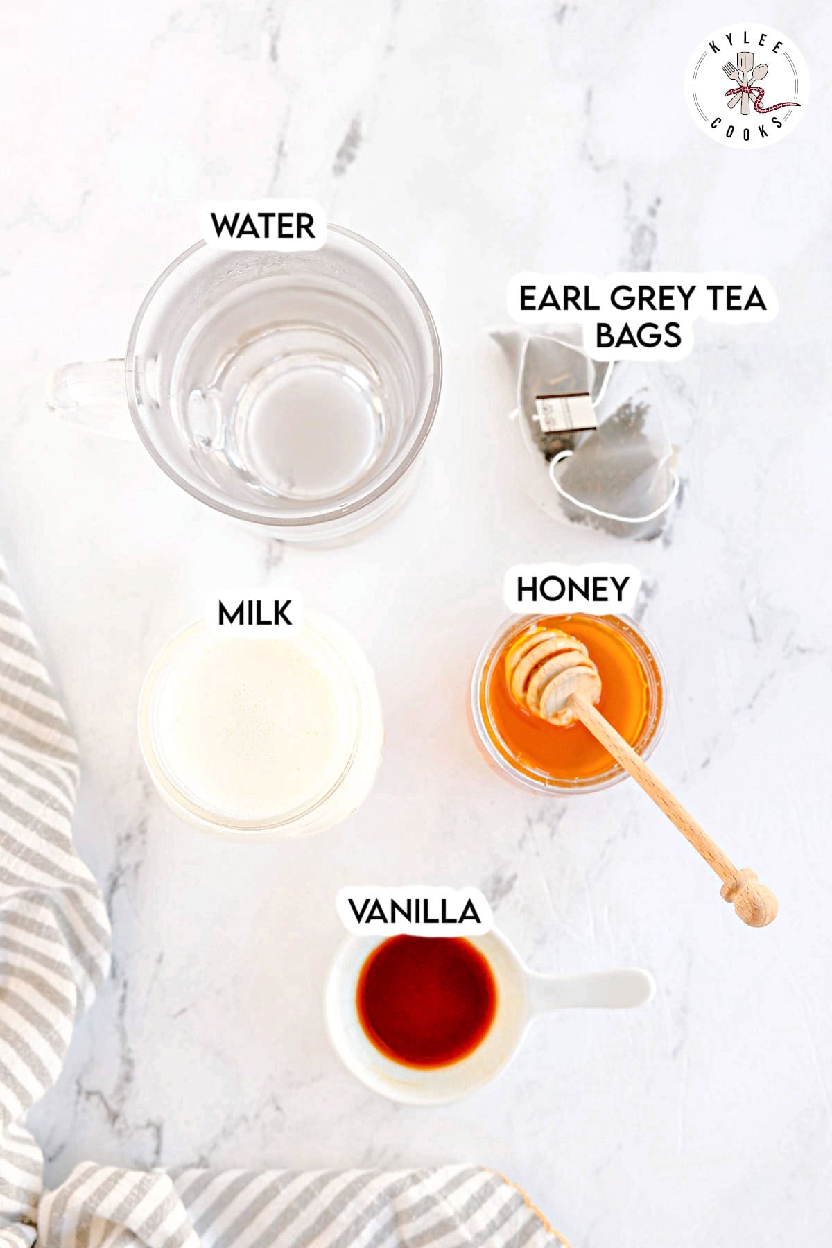 A mug of water, Earl Grey tea bags, milk, honey, and vanilla. Text on the image says 'WATER', 'EARL GREY TEA BAGS', 'MILK', 'HONEY', 'VANILLA'.