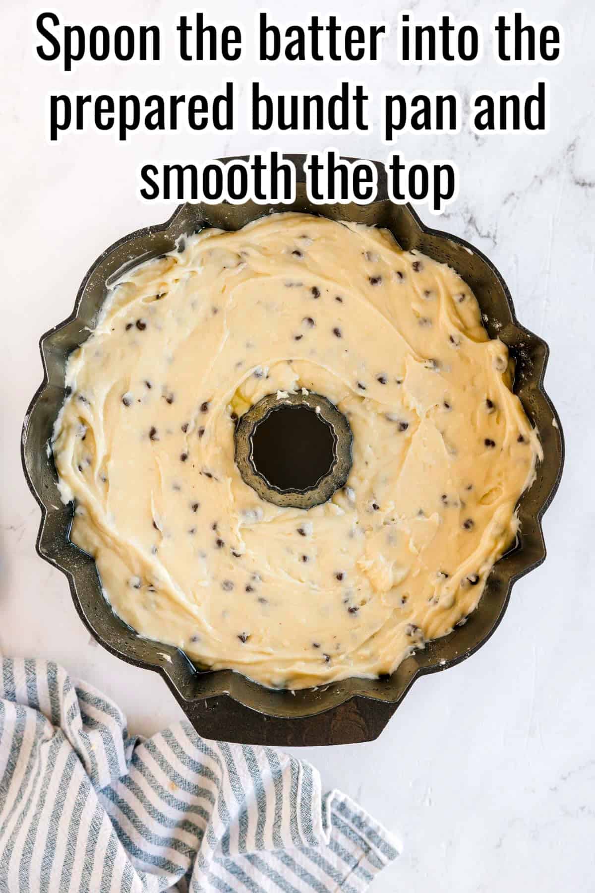 A bundt pan filled with chocolate chip batter. Text on the image says 'Spoon the batter into the prepared bundt pan and smooth the top'.