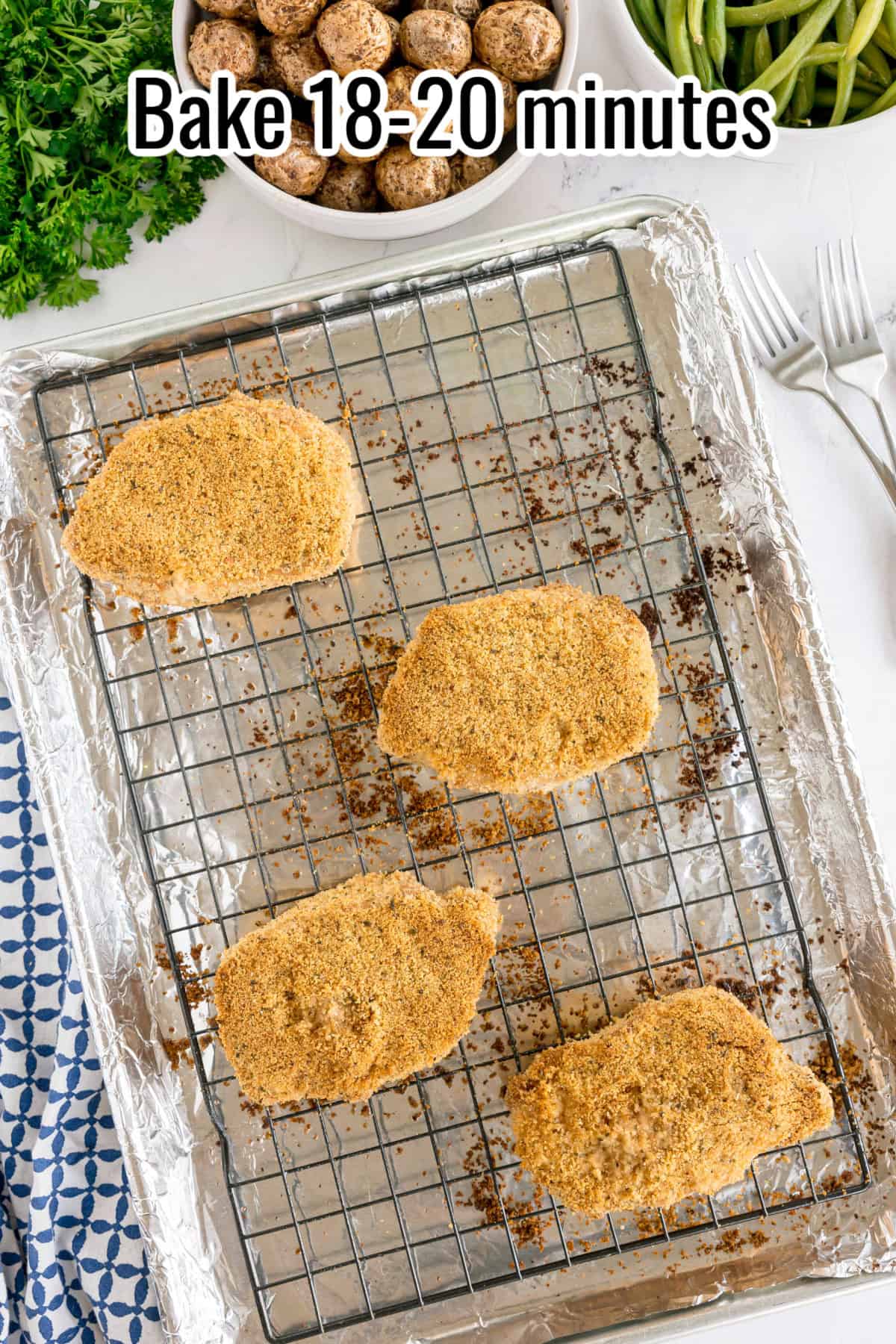 Baked breaded pork chops on a wire rack. Text on the image says 'Bake 18-20 minutes'.