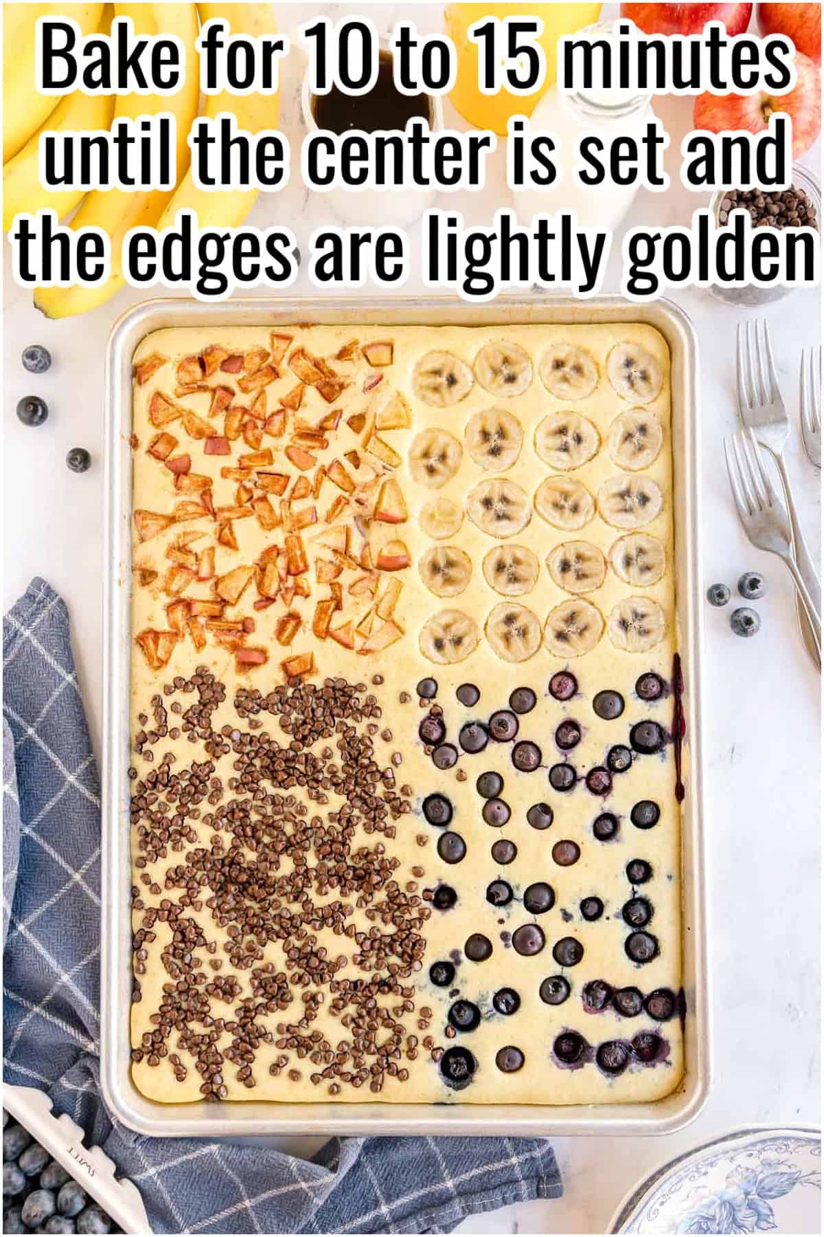 Fully baked sheet pan pancake with golden edges and topping sections. Text on the image says 'Bake for 10 to 15 minutes until the center is set and the edges are lightly golden'.