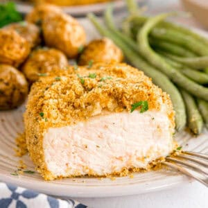 Breaded pork chop with green beans and roasted baby potatoes.