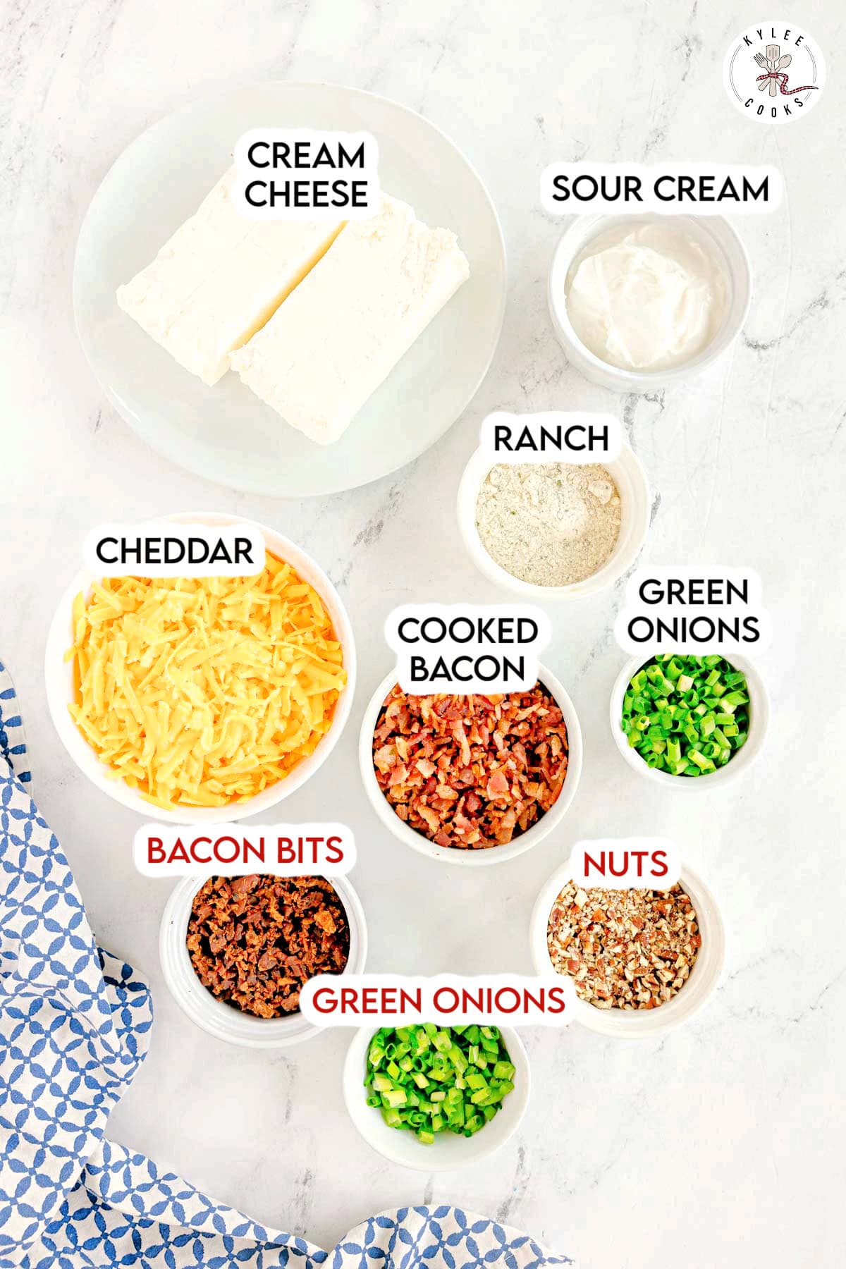 Small bowls filled with cream cheese, sour cream, ranch powder, cheddar, cooked bacon, green onions, bacon bits, and nuts. Text on the image says 'CREAM CHEESE', 'SOUR CREAM', 'RANCH', 'CHEDDAR', 'COOKED BACON', 'GREEN ONIONS', 'BACON BITS', 'NUTS'.