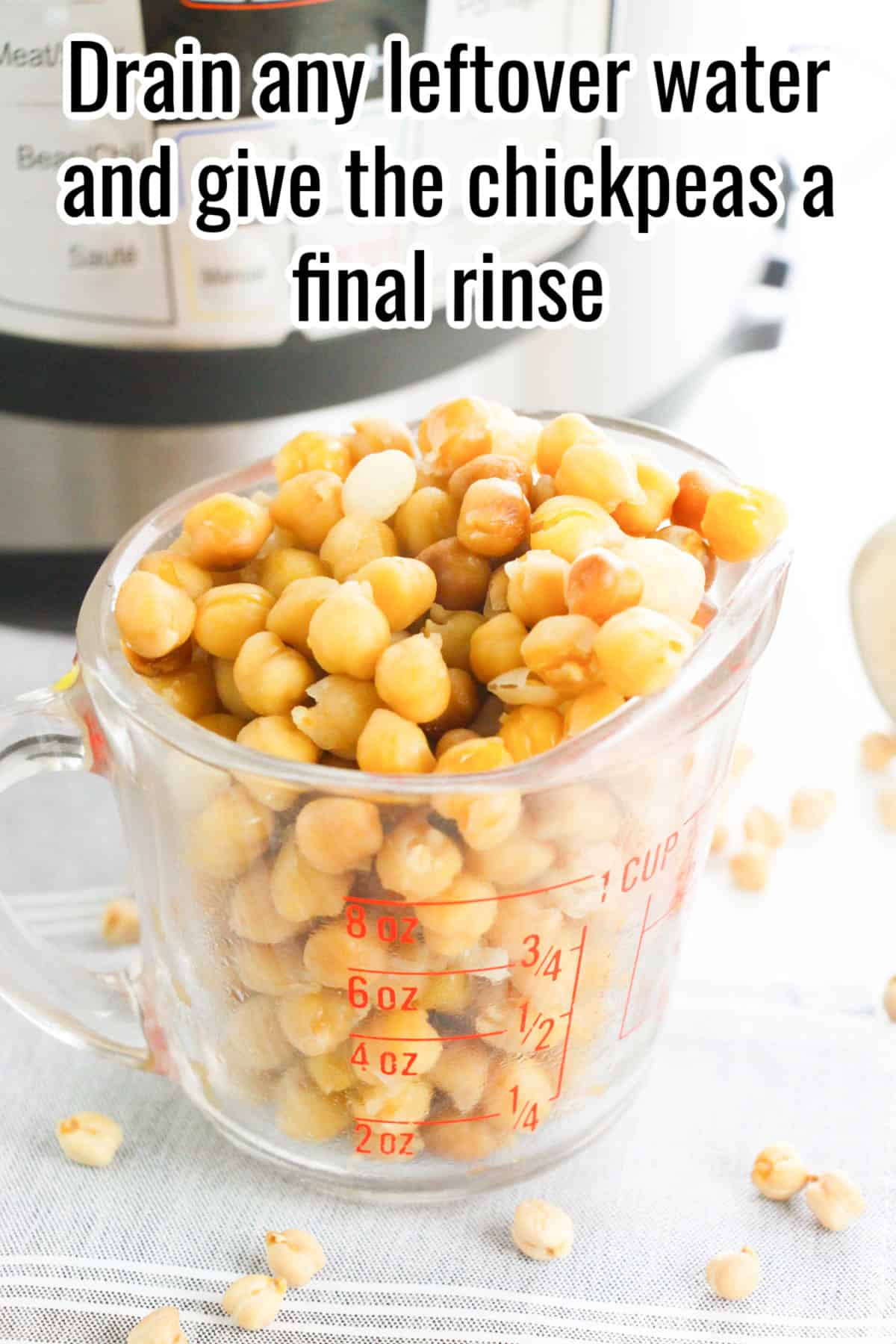 Cooked chickpeas in a measuring cup. Text on the image says 'Drain any leftover water and give the chickpeas a final rinse'.