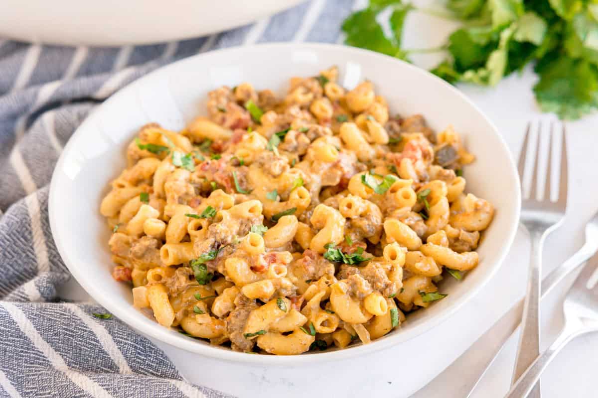 A bowl of taco mac and cheese topped with chopped cilantro.