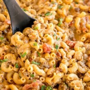 Close-up of creamy taco mac and cheese with beef and diced tomatoes.