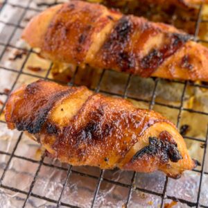 Close up bacon wrapped chicken on a wire rack.