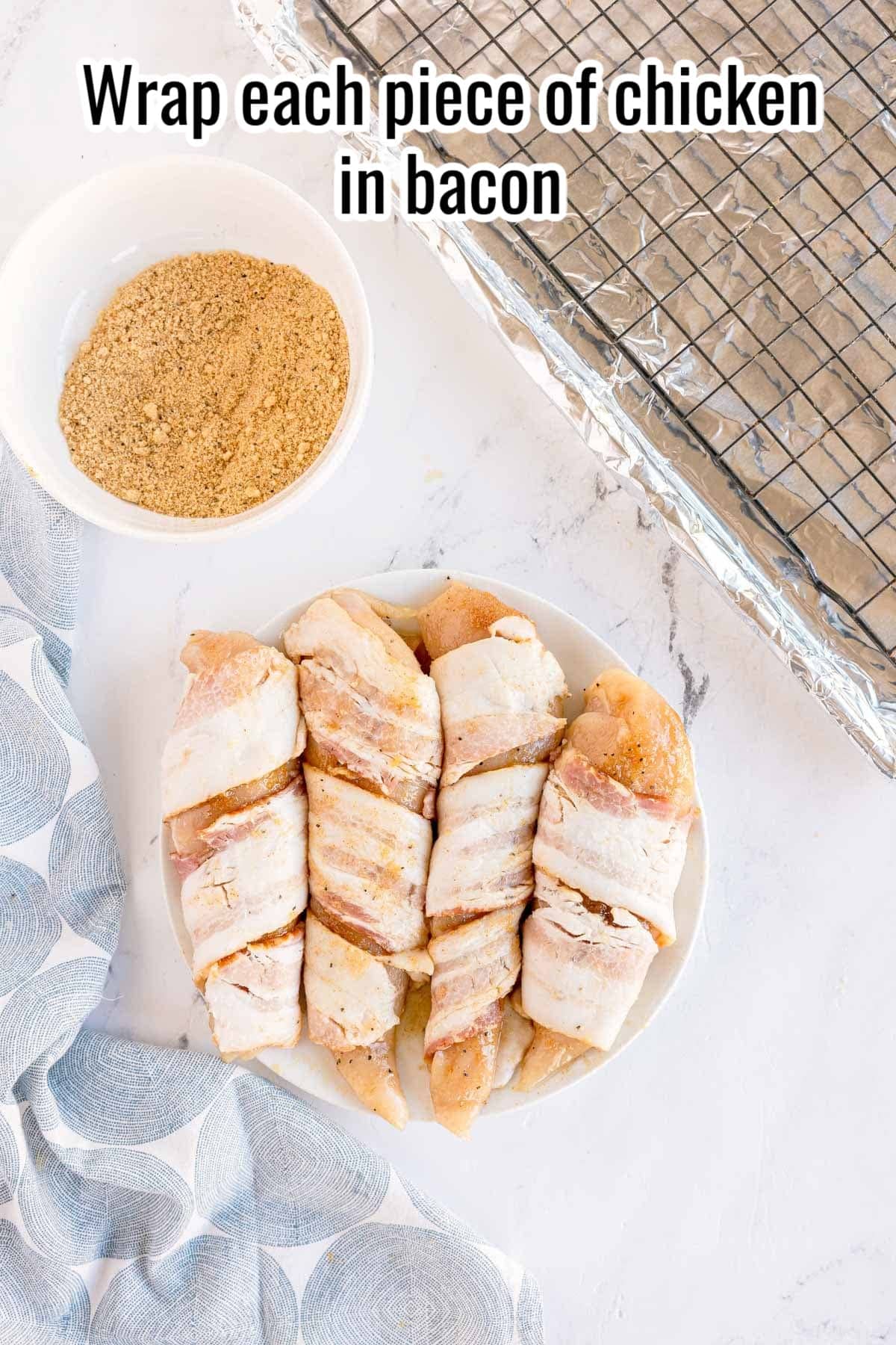 Chicken breasts wrapped in bacon on a plate. Text on the image says 'Wrap each piece of chicken in bacon'.
