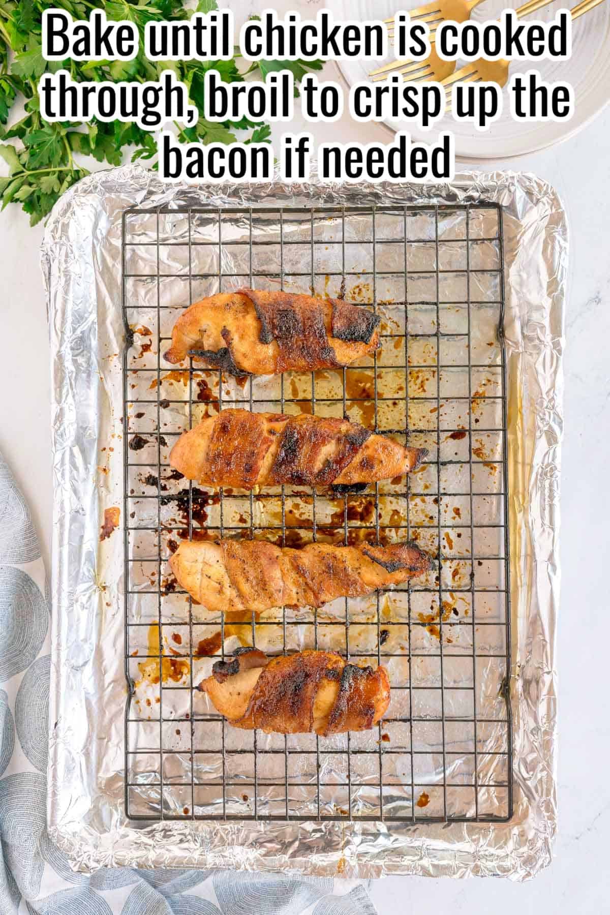 Bacon wrapped chicken baking on a wire rack over a foil lined sheet pan. Text on the image says 'Bake until chicken is cooked through, broil to crisp up the bacon if needed'.