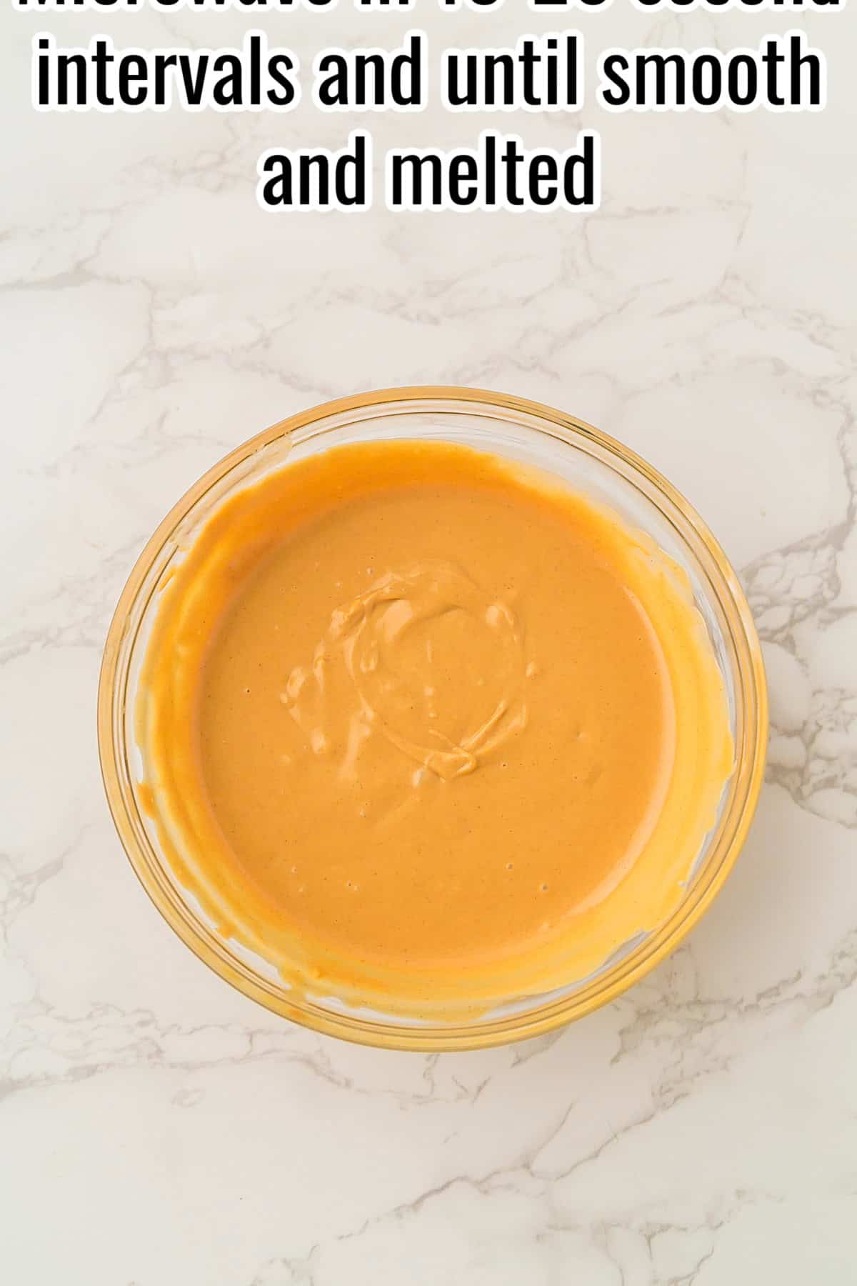 Melted peanut butter and butterscotch mixture in a glass bowl. Text on the image says 'Microwave in 30 second intervals and until smooth and melted'.