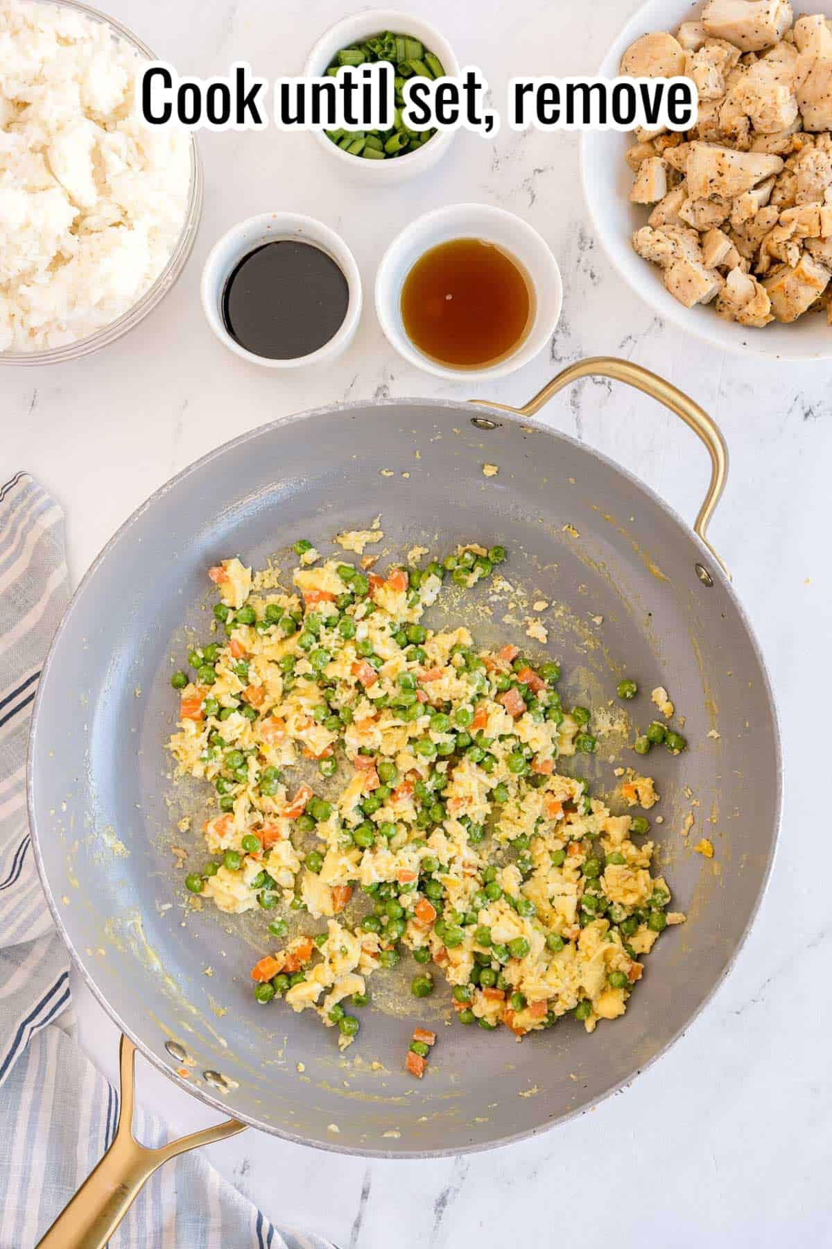 Scrambled eggs mixed with peas and carrots in a skillet. Text on the image says 'Cook until set, remove'.