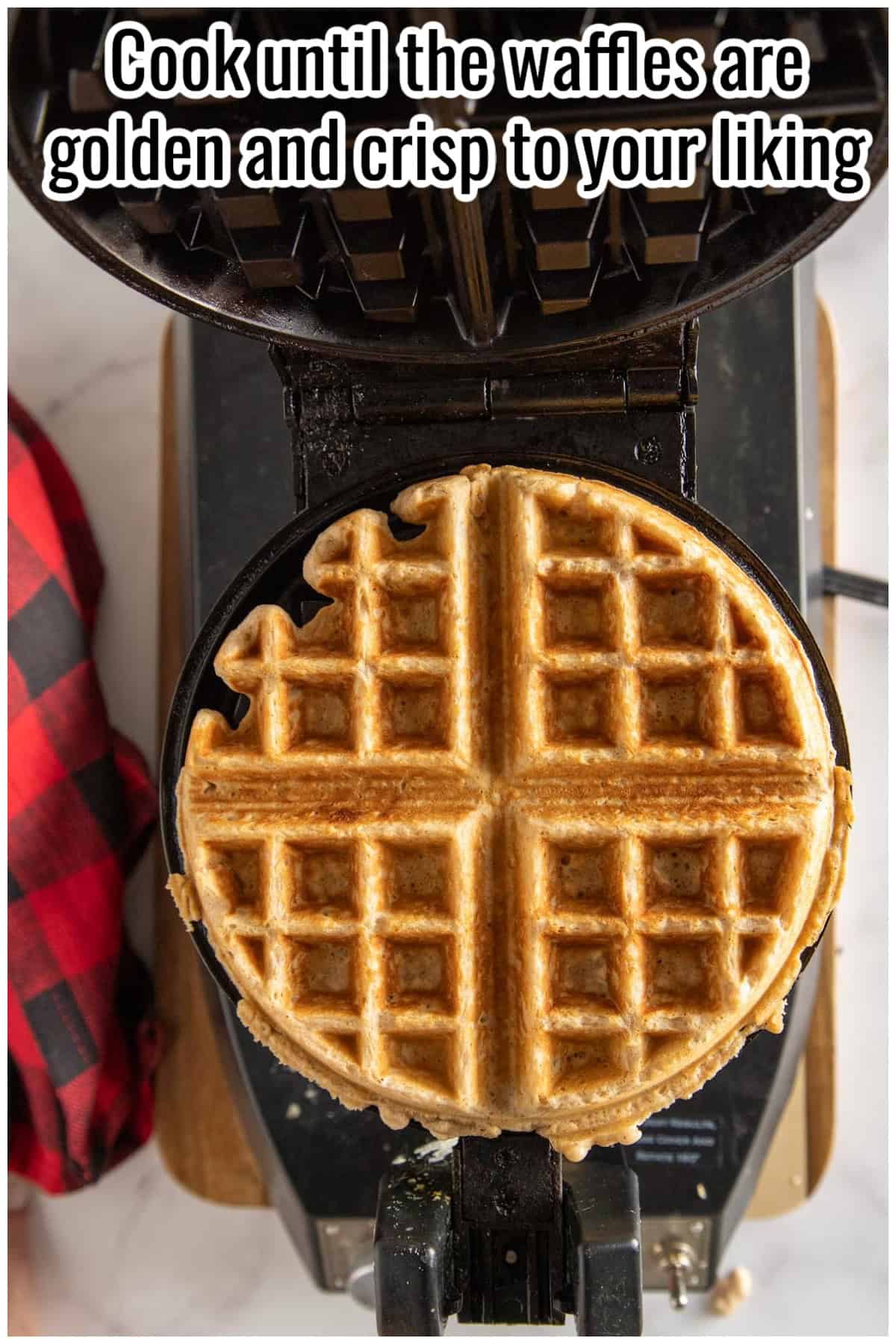 A golden cooked waffle in a waffle iron. Text on the image says 'Cook until the waffles are golden and crisp to your liking'.
