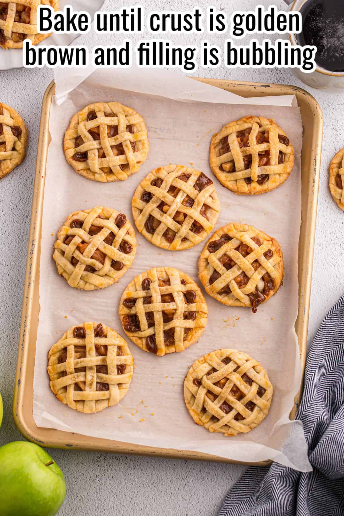 A baking sheet lined with parchment paper holds nine small lattice-topped pies. The crusts are golden brown and some filling is visible. Text at the top gives baking instructions.